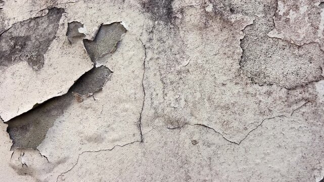Close up of peeling paint on cement render wall, weathered facade texture background.