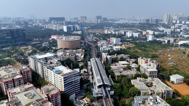 Aerial view of HITEC City&rsquo;s tech corridor metro line slicing through glass towers, corporate campuses, and expanding urban grids showcasing Hyderabad&rsquo;s fast-paced digital and infrastructure growth.
