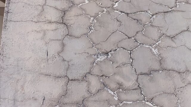 Close up of cracked exterior render with worn paint, distressed facade surface texture background.