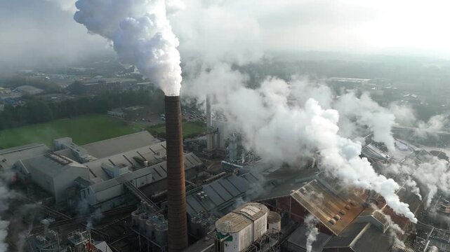 Industrial aerial perspective of sugar production factory in Bury St Edmunds UK with active machinery and chimney stacks emitting steam