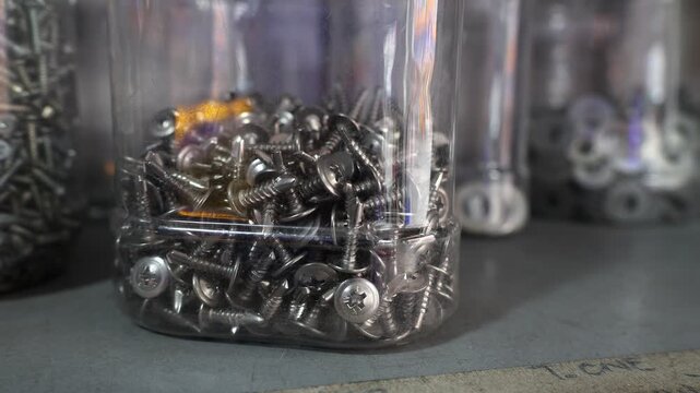 Man examines the selection of goods in a hardware store. Close up view of male hands choosing construction parts.