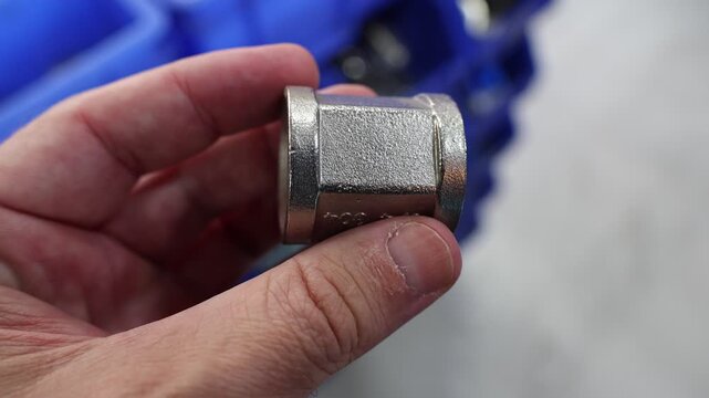 Man examines the selection of goods in a hardware store. Close up view of male hands choosing construction parts.
