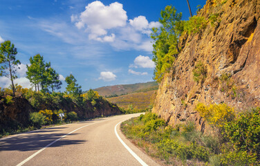 View of beautiful mountain landscape through the windscreen on a sunny day. Driving a car on mountain winding road. Spain, Europe