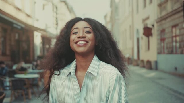 Traveler enjoying relaxed city walk, Spontaneous moment showing woman with textured hair in lively urban setting