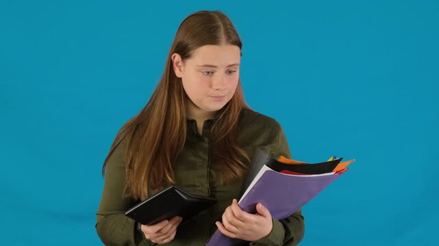 Stressed young woman secretary looks through folders calculating research results. Female worker makes work report sheet slow motion