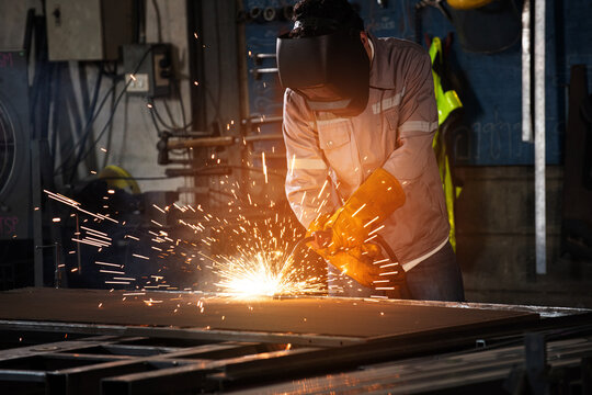 Welding welder spark metal steel workshop industrial factory plants technician fuses plate with arc as bright fire flashes and safety gear shields face and hand