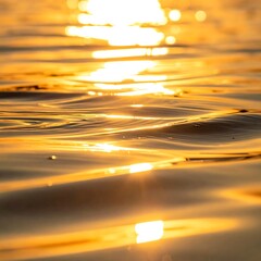 Sunlit water surface with blurry light flares creating warm golden hues reflecting on gentle waves
