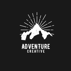 Fototapeta premium Grunge Mountain Adventure Creative Logo Design with Sun Rays on Black Background