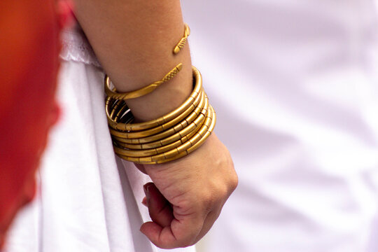 Pulseiras de metal dourado no pulso de mulher. 