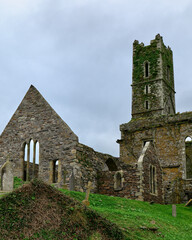 The weathered stone walls of the abbey stand out against the grey sky.