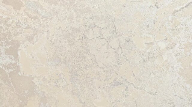 A close-up view of a light beige marble surface with subtle veins and textures. The stone has a polished finish, showcasing its natural beauty and elegance.
