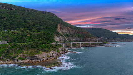 Fototapeta premium Sea Cliff Bridge on the southern coast of Sydney with sweeping Ocean Views and Mountain terrain. a major Bridge Road on the beautiful Australian coastline 