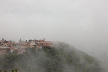 Fototapeta premium Scenic mountain town of Sighnaghi disappearing into the white mist