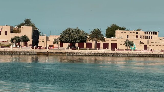 Scenic views of Dubai's Al Seef heritage district featuring traditional Arabian architecture, wind towers, narrow alleyways, and waterfront scenery along the creek during a sunny day.

