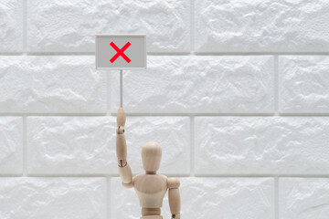 バツのプレートをあげたデッサン人形