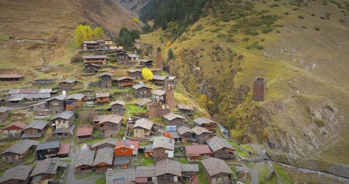 Aerial View of Dartlo Village in Tusheti, Georgia, Featuring Ancient Stone Towers and Traditional Houses with a Cinematic Pan to the Right Over the Mountain Landscape.
