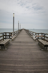 Obraz premium Blick auf einen grossen Holzsteg mit Sitzbänken und einem Schiff am Horizont auf der Ostsee in Heiligendamm