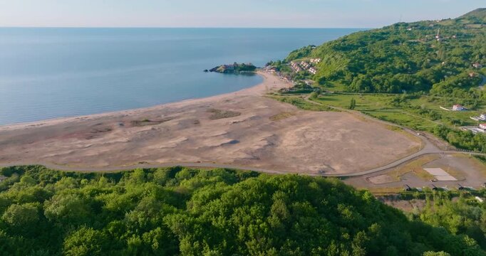 Drone footage gliding over forests towards Mugada Beach in Bartin. A smooth aerial shot moving from green hills to golden sands and the blue Black Sea.