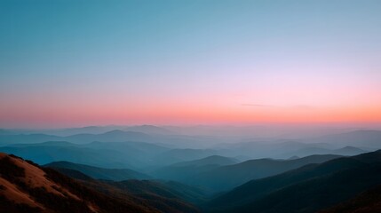 Fototapeta premium Layered mountain range at dusk with a gradient sky transitioning from pink to blue