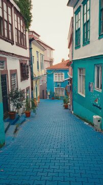 An impressive top-to-bottom camera tilt showcasing colorful historic houses and blue cobblestone streets in the Taflanalti neighborhood of Giresun, Turkey.