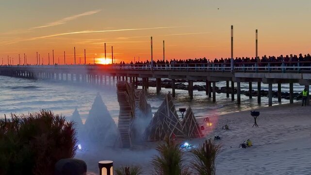 Jurgines (St. George's Day) Celebrating in Palanga. Burning a dragon figure on the Baltic Sea coast. Fire engulfs a large dragon-shaped structure made of wood on the sandy beach of Palanga, Lithuania