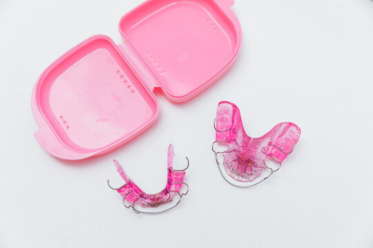 Orthodontic twin block with storage case isolated on white background, pediatric dentistry and removable structures for bite correction.
