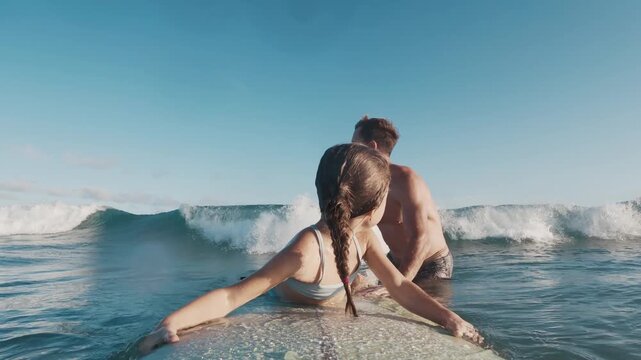 Kid surfs. Little girl learns surfing with her father and tries to keep balance on the surf board