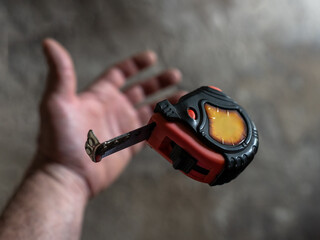 Naklejka premium The mechanic throws the measuring tape out of his hand and it goes into free fall.