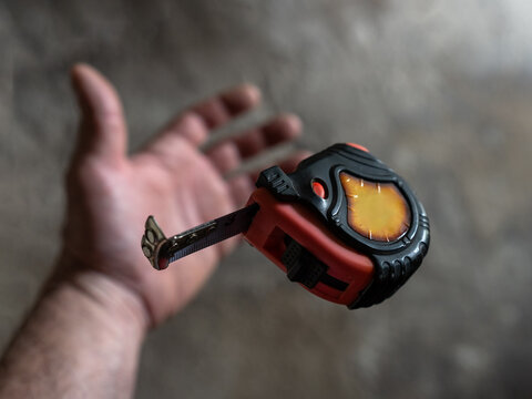 The mechanic throws the measuring tape out of his hand and it goes into free fall.