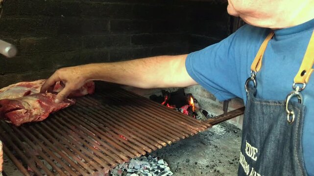 Authentic Argentine Asado &ndash; Close Up of Man Preparing Meat on Charcoal Grill