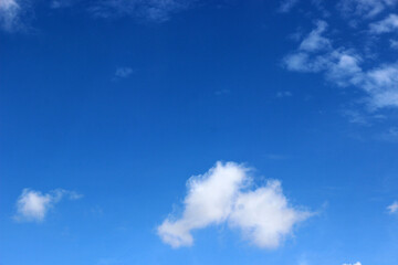 Obraz premium A bright blue sky background with beautiful clouds; a bottom-down, wide-angle view.