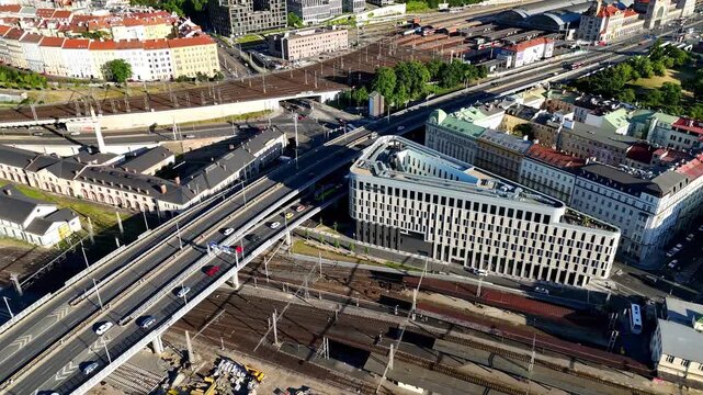Top-down drone view of urban traffic flow with strong sunlight and shadows, highlighting city movement, road geometry, and dynamic transport patterns from above.