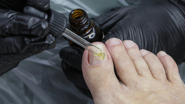 A person is applying nail polish to their toes