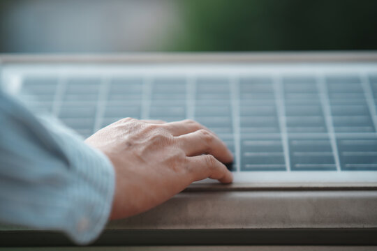 A hand touching the trackpad of a laptop computer during operation in a modern indoor setting