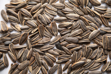 Unhulled sunflower seeds on white background.