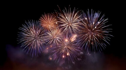 Spectacular fireworks burst in vibrant colors across the dark night sky illuminating the darkness with dazzling light patterns