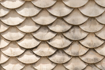 Moss-covered concrete wall, fish-scale design resembling Japanese koi Guotaku. Bright sun, strong shadows. Urban-nature fusion. © Маргарита Трушина