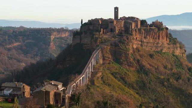 Ghost city Civita di Bagnoregio aerial reveal shot turning to medieval bridge and hilltop village morning soft light calanchi valley landscape Lazio Italy travel destination dji air 3s 10-bit 4k