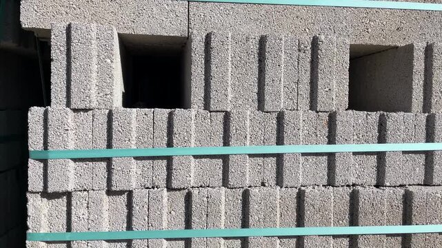 Stacked concrete blocks with teal straps creating geometric pattern background