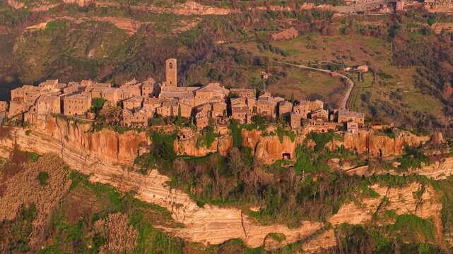 Ghost city Civita di Bagnoregio aerial reveal shot turning to medieval bridge and hilltop village morning soft light calanchi valley landscape Lazio Italy travel destination dji air 3s 10-bit 4k