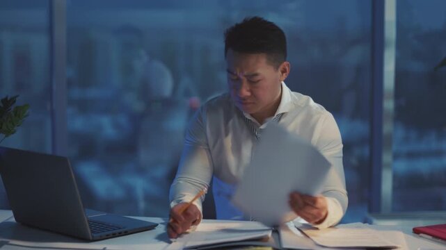 Dedicated analyst meticulously sorting spreadsheets and reports under cool lighting during late hours