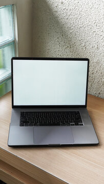 Modern Space Gray MacBook Pro Mockup on Minimalist Wooden Desk with Blank Screen