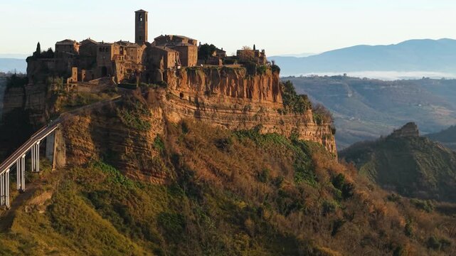 Ghost city Civita di Bagnoregio aerial panoramic view turning left to right medieval hilltop village and calanchi mountains landscape morning soft light Lazio Italy dji air 3s 10-bit 4k