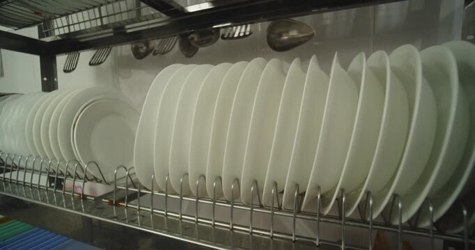Clean White Plates Drying in Commercial Kitchen Dish Rack