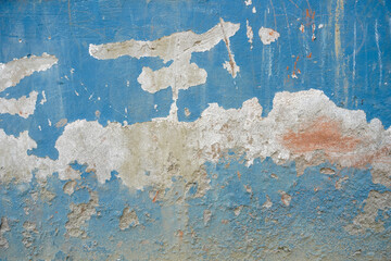 Fototapeta premium peeling blue paint on rough concrete wall texture
