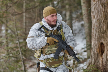 Obraz premium Armed Soldier In Winter Camouflage Patrol Carrying Rifle Through Snowy Forest During Training Operation