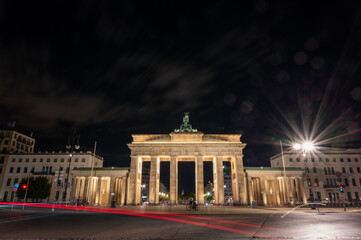 Berlin, germany, august 14, 2023. Brandenburg gate in berlin standing illuminated at night, featuring historic architecture with long exposure car light trails