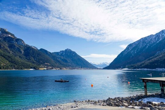 Pertisau west of Lake Achen. To the right, the slopes of the B&auml;renkopf opposite the Klobenjoch and Ebner Joch above Buchau, Maurach, and Jenbach. On the horizon, the snow-capped Zilletal Alps
