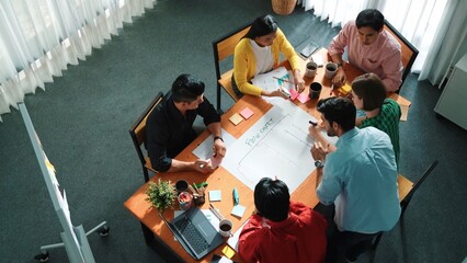 Top down view of diverse people brainstorming and making scrum task board. Group of skilled business team working together and writing sticky notes to share plan and using kanban board. Convocation. © InfiniteFlow