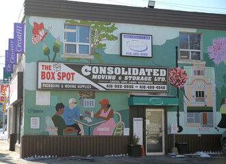 Fototapeta premium exterior building wall with mural by Andrea Manica and signs of The Box Spot, a moving supply store, located at 542 Mt Pleasant Rd, Toronto
